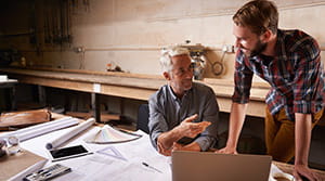 Father and son discuss family business in workshop