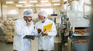Two managers of a food production plant talking in the plant