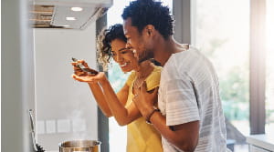 Couple tasting sauce in new kitchen