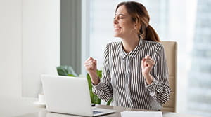 Person cheering and smiling at computer