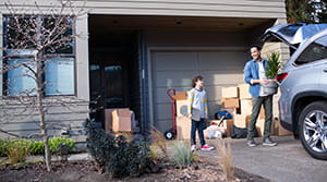Father and son unpack car as they move into their new home, financed by Banner Bank
