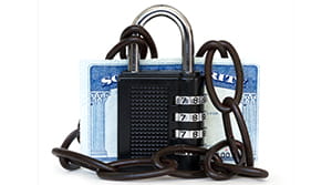 Social Security card covered by a black padlock and black chains