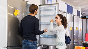Couple looking at fridge in appliance store