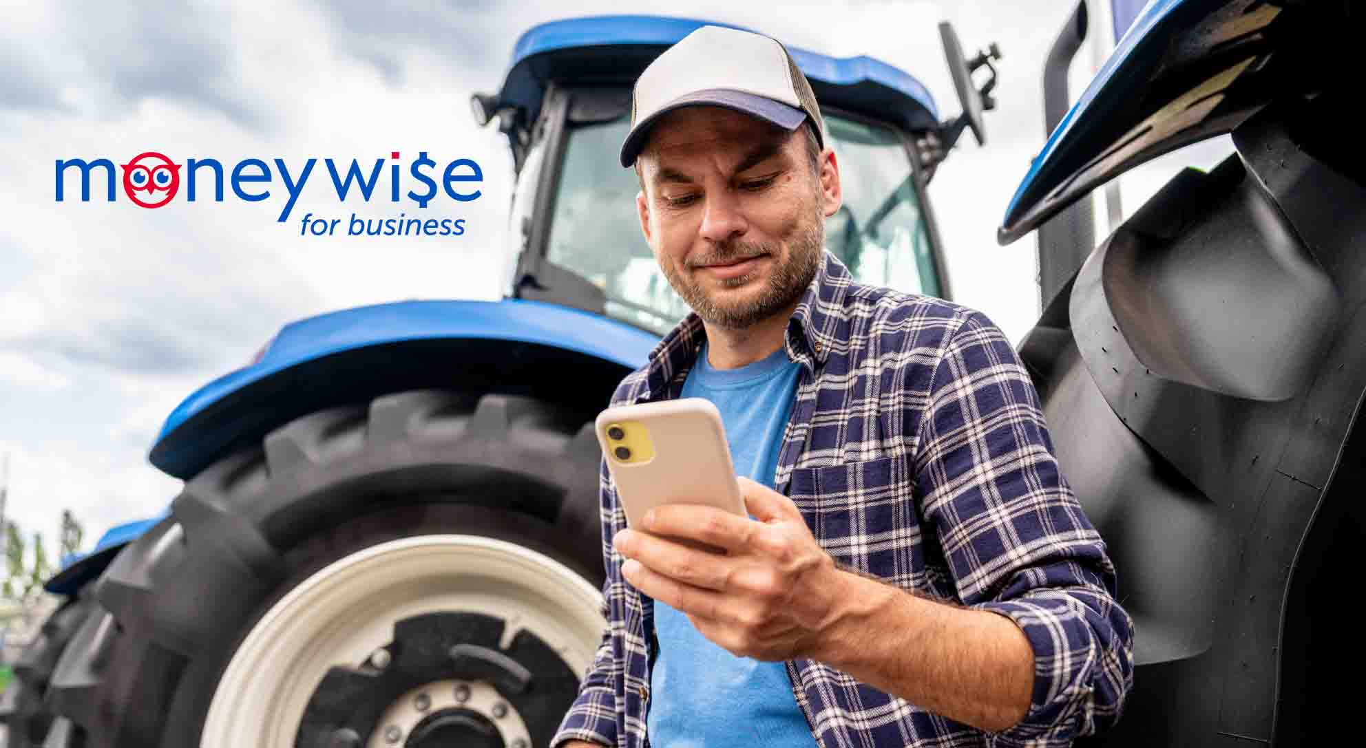 Person on phone in front of tractor and moneywise logo