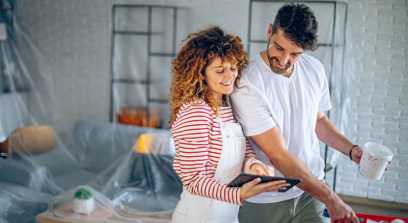Two people looking at tablet while working on home