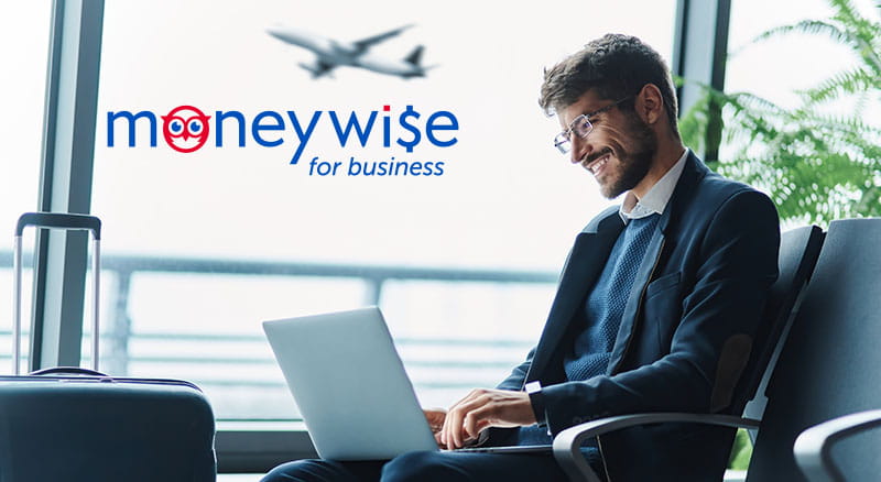 Person typing on laptop in the airport with MoneyWise logo