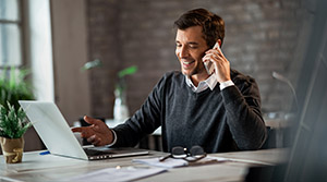 Person on phone while at computer