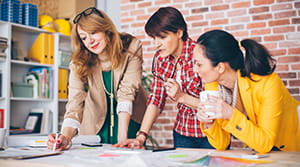 Three colleagues looking at plans for office