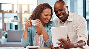 Couple looking at a tablet and smiling