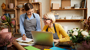 Two flower shop employees in discussion at computer