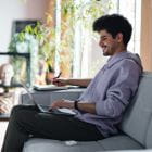 A man on a couch looking at a computer