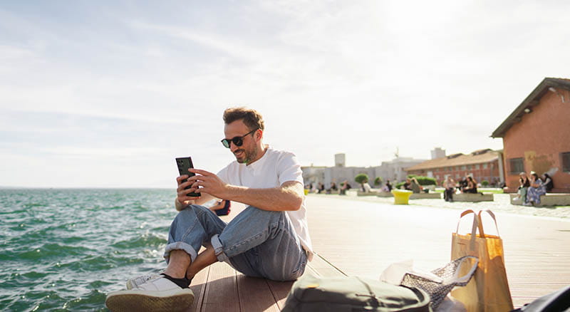 Person using phone on the waterfront
