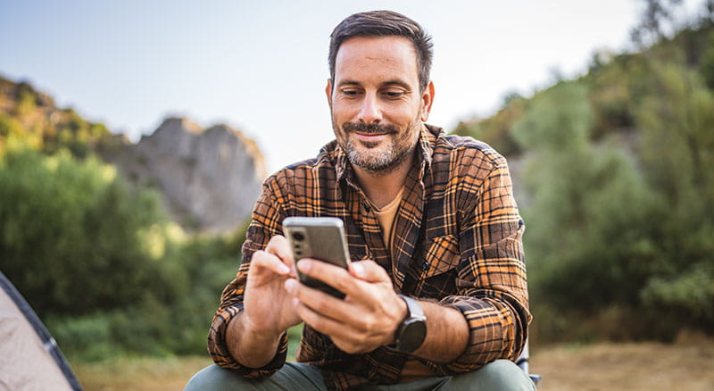Person looking at mobile phone in nature