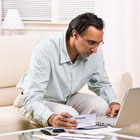 Man sits at laptop and pays her credit card bill Banner Online Banking and Bill Pay