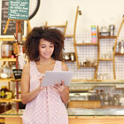 Business woman owner in her shop looks at her Banner Bank accounts from her tablet