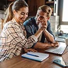 Couple looking at paperwork and high fiving