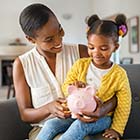 Mother and daughter using piggy bank