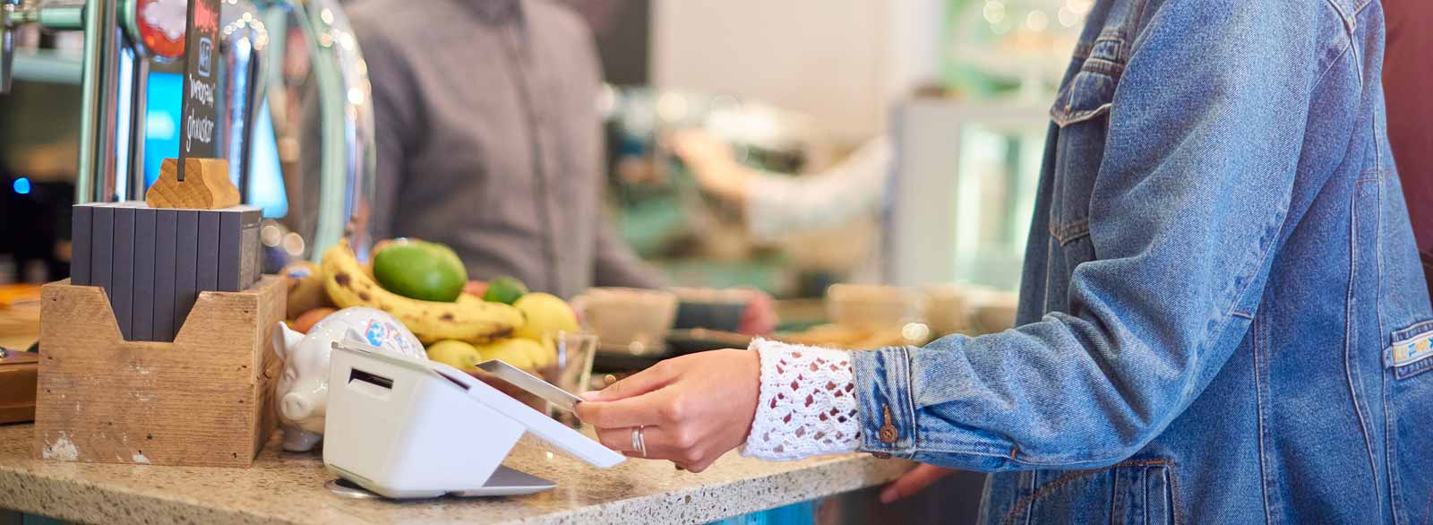 Person taps card on contactless payment terminal