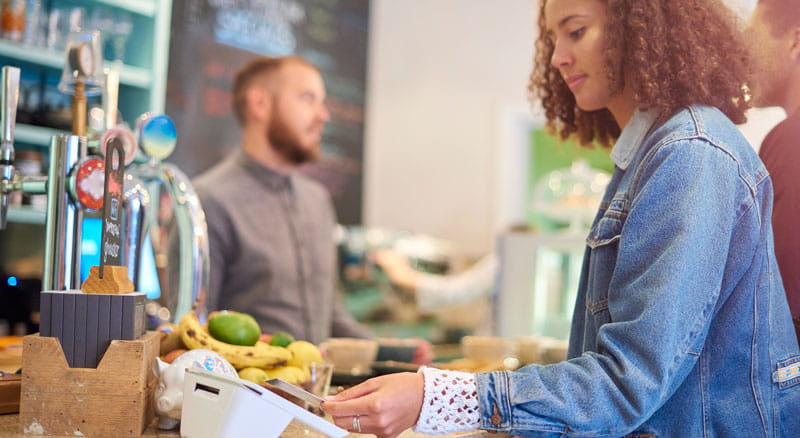 Person taps card to pay at contactless terminal