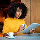 A woman uses her debit card to pay for coffee