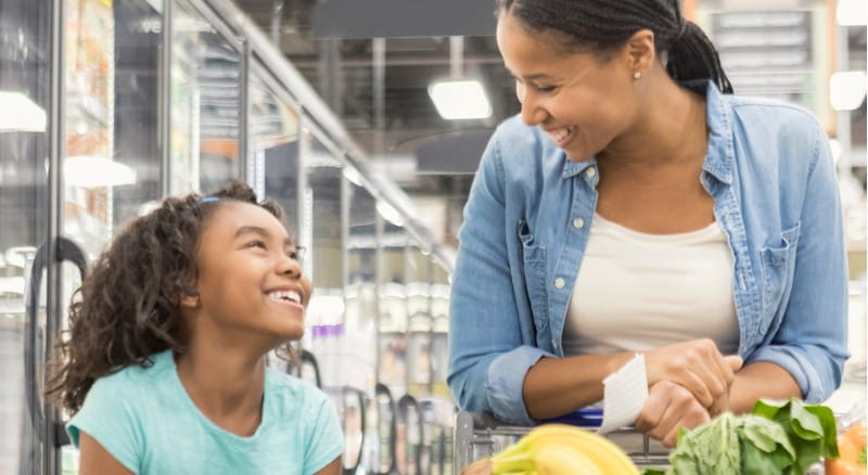 Mom and daughter shop at grocery store using their Banner Bank debit card