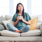 A woman sitting on a couch with a mug
