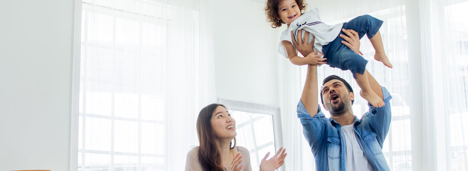 Parents hold child in air