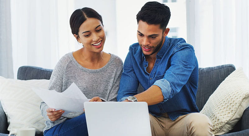 Couple looking at bills and laptop