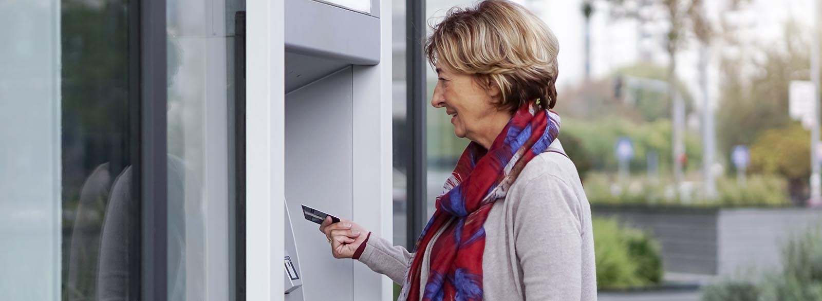 Person inserting debit card into ATM