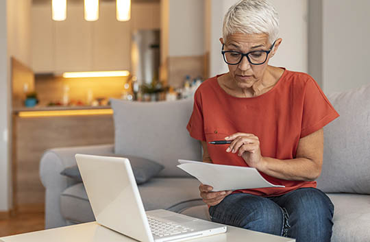 A woman looks at her online banking from her laptop