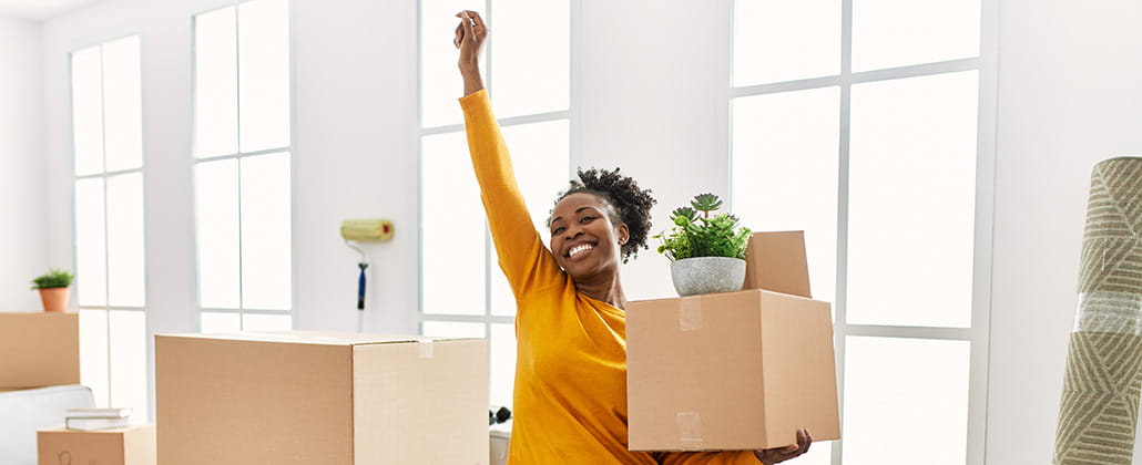 Person holding a moving box with arm in the air in new space