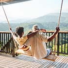 Two people on a porch swing looking at mountains