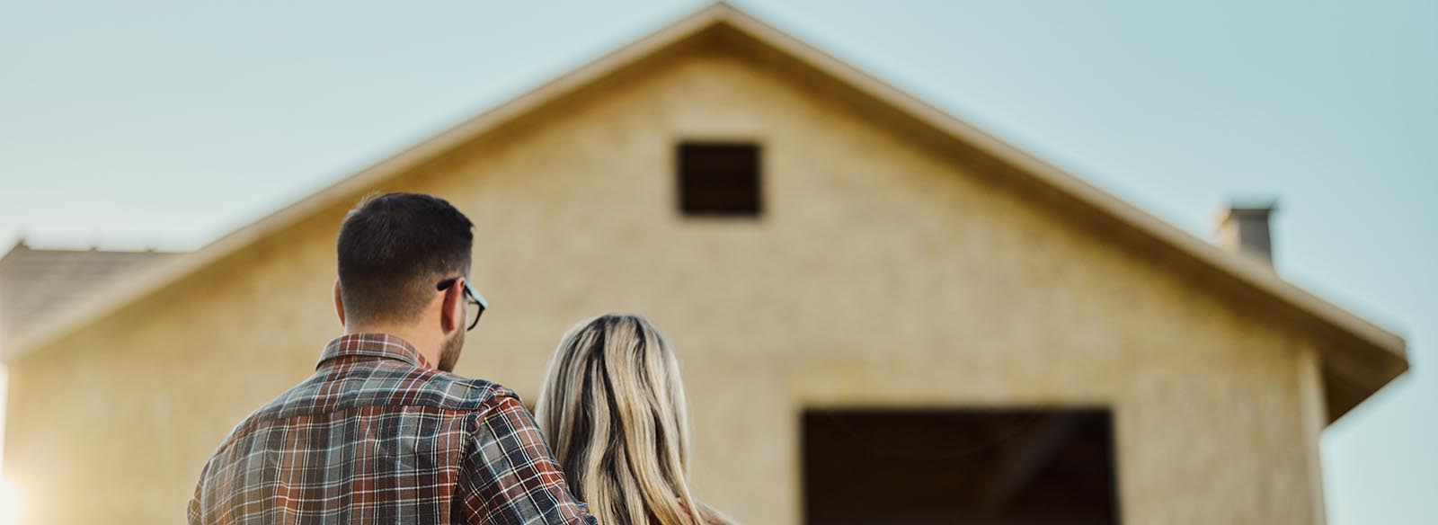 Two people looking at a home being built