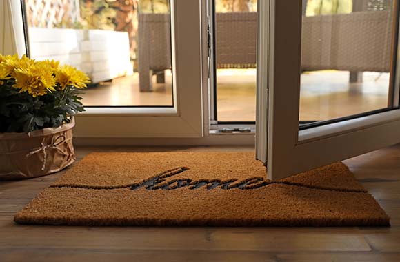 Open door with a home welcome mat