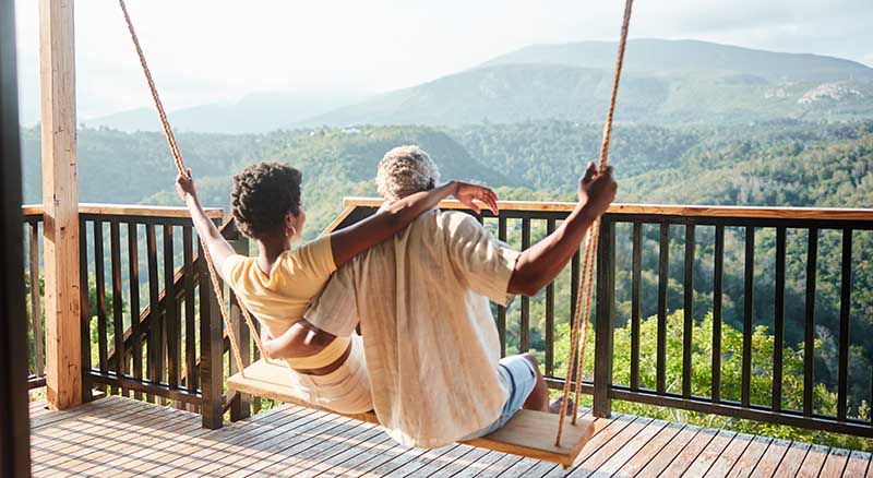 Couple on porch swing looking out at mountains