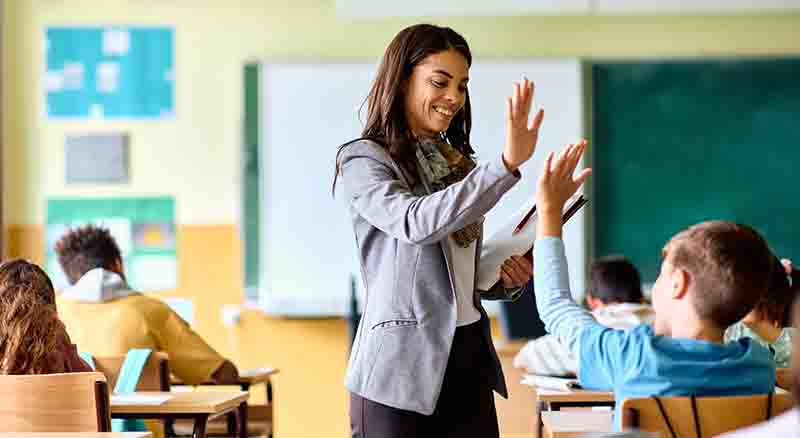 Teacher giving a high five to a student in the classroom
