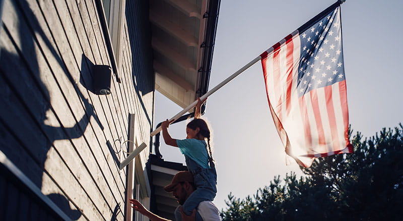 Father and son putting up an American flag