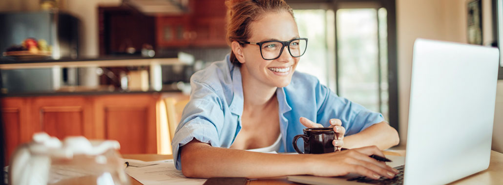 Woman smiles while using laptop