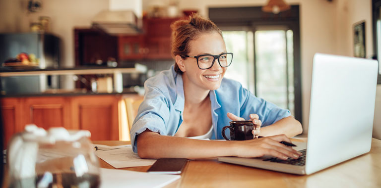 Woman smiles while using laptop