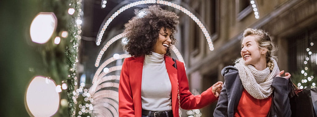 Two women walking and smiling in outdoor holiday setting