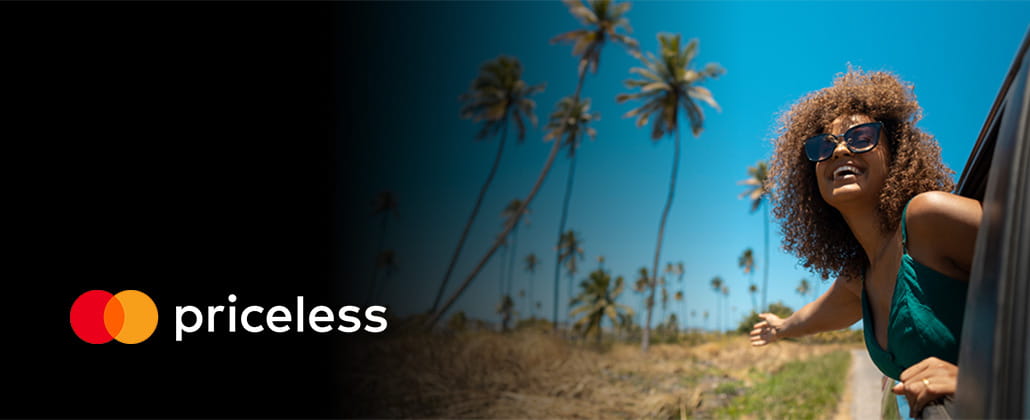 Person leaning out of a car in a tropical location with priceless logo