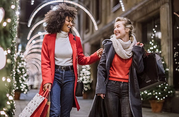 Two women walking and smiling in outdoor holiday setting