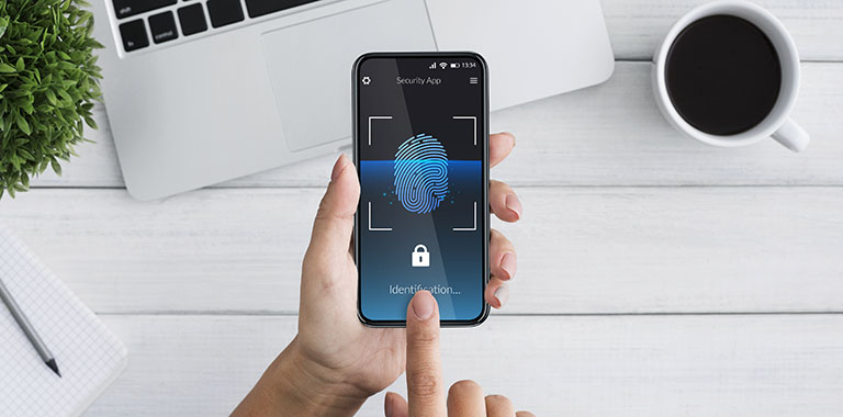 Person holding phone with fingerprint login on the screen