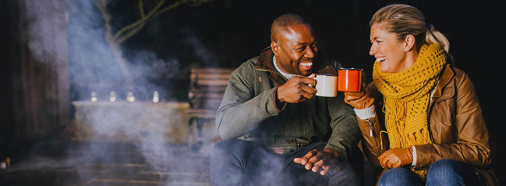 Two people cheering at a campfire
