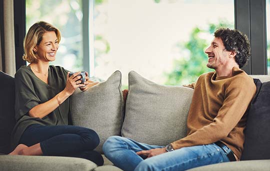 Couple sitting on couch smiling