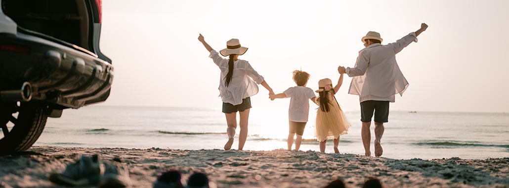 Family kicking off shoes and celebrating at the beach