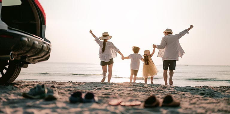 Family kicking off shoes and celebrating at the beach