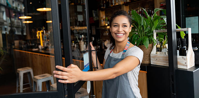 Person holding open a door to a business
