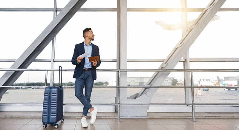 Man in airport looking at departing plane