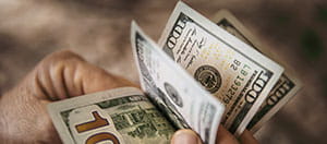 Person counting $100 bills